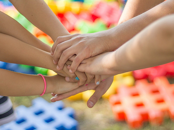 Zusammenhalt Ehrenamt Mehrere Hände treffen sich in der Mitte um Zusammenhalt abzubilden
