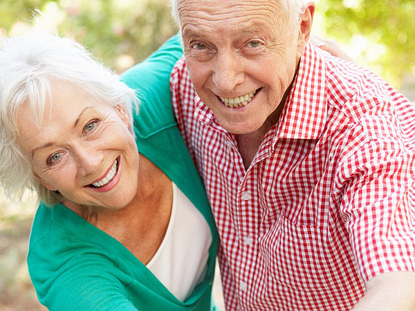 ein älteres Pärchen tanzt im Grünen