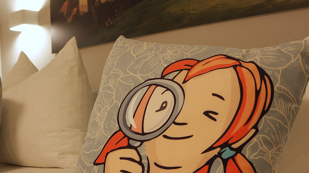 Kissen mit dem Gesicht von Pine im Hotelzimmer