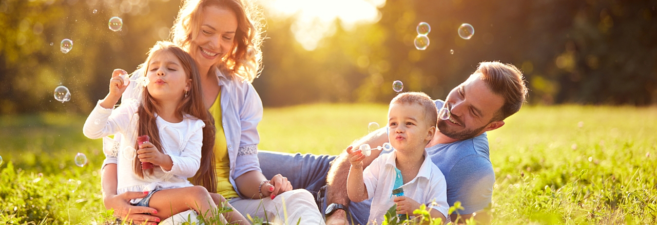 Familie im Sonnenschein macht Seifenblasen