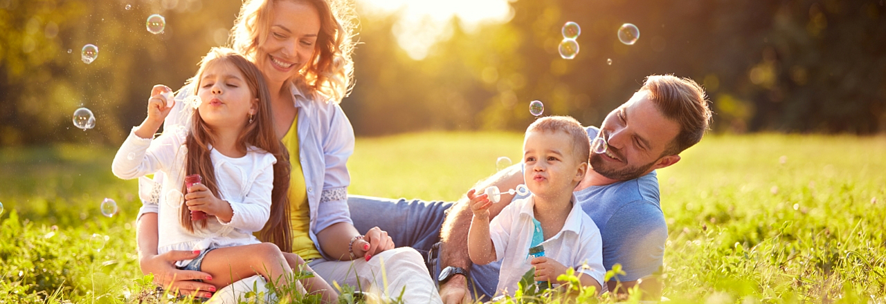 Familie im Sonnenschein macht Seifenblasen