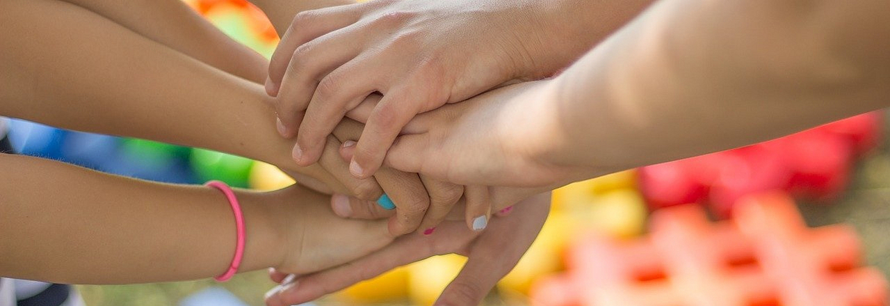Mehrere Hände treffen sich in der Mitte um Zusammenhalt abzubilden