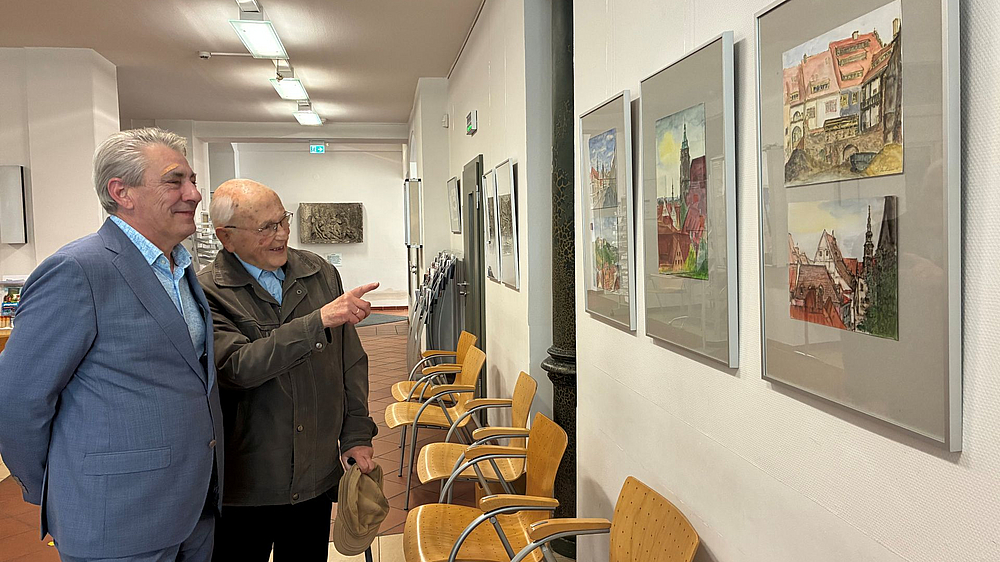 OB Lochner und der Künstler schauen sich gemeinsam die Ausstellung im Rathaus an