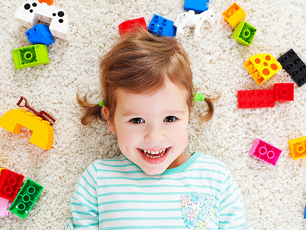 Mädchen mit Bausteinen in der Kinderbetreuung