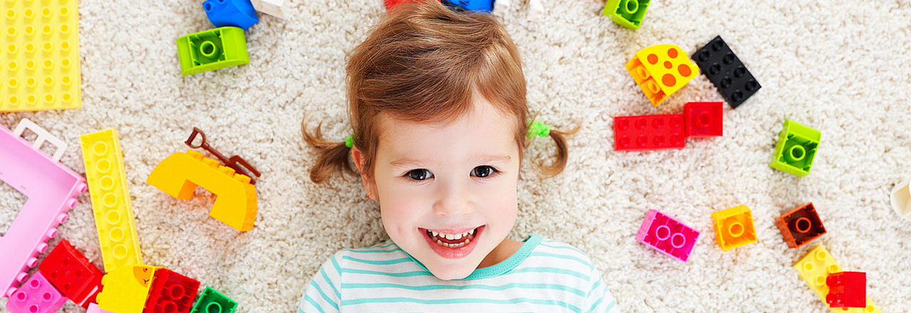 Mädchen mit Bausteinen in der Kinderbetreuung