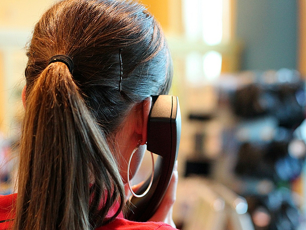 Frau telefoniert mit Telefonhörer