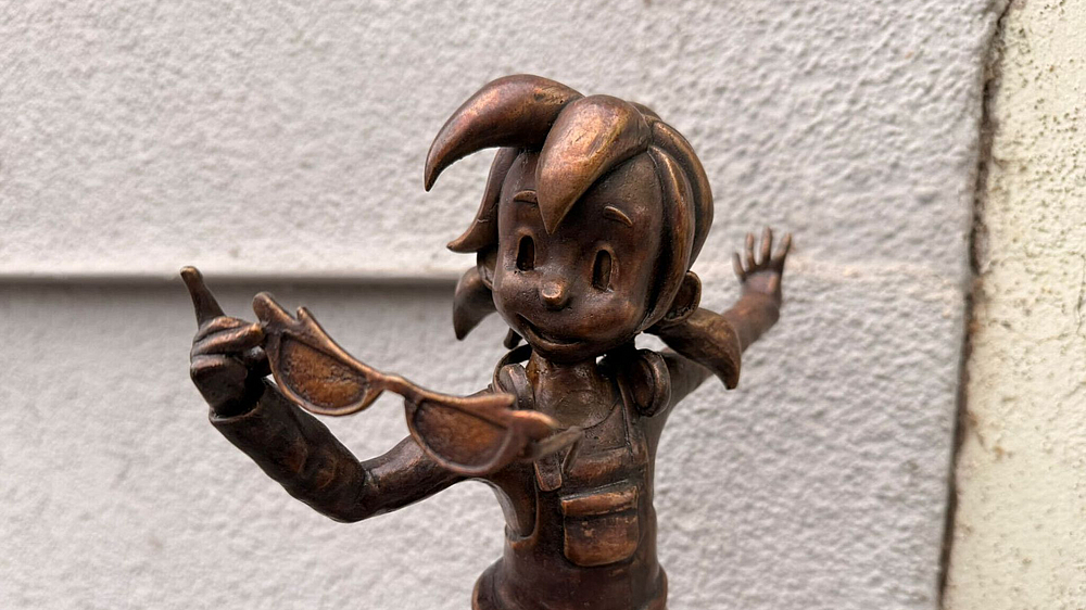 Bronze-Pine des Optik Studios in nahaufnahme mit Brille