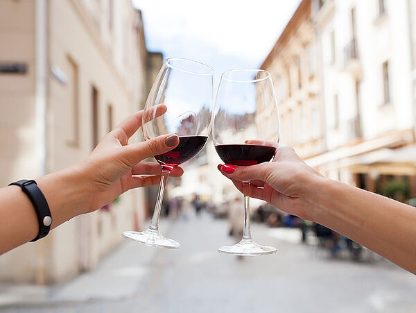 hands close up of couple toasting glasses of wine, traveling in europe, summer vacation, drinking alcohol, point of view