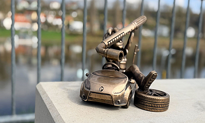 Autohaus Schulze - Pine von vorn Frontansicht der Bronze-Pine platziert auf Sandsteinblock