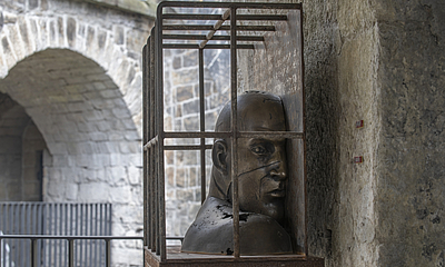 Bronzeskulptur von Ludmila Seefried-Matějková, Darstellung einer männlichen Büste im Inneren einer Gitterkonstruktion