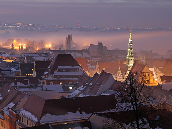 Blick über Pirnas schneebedeckte Altstadt bei Nacht
