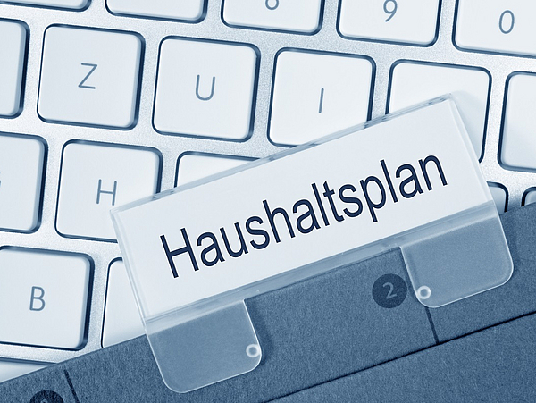 Tastatur und Aktenmappe als Sinnbild für Bekanntmachungen zum Thema Finanzen