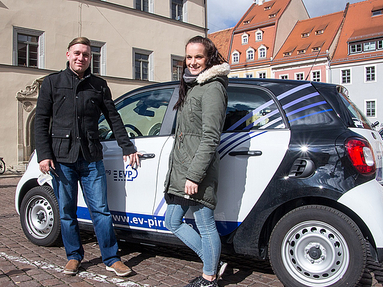 Zwei Stadtmitarbeiter vor einem Elektroauto der EVP