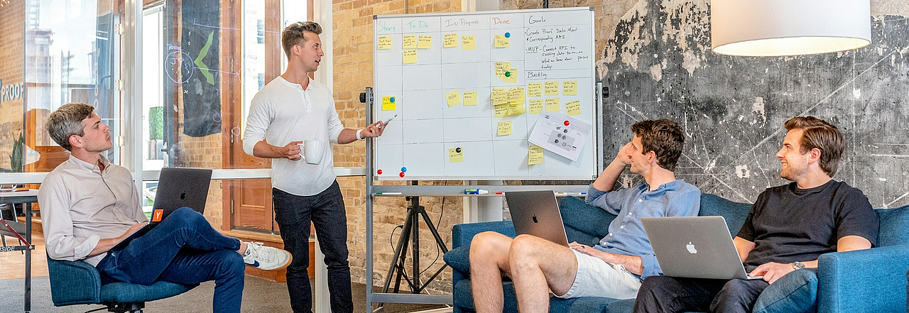 eine Gruppe von Menschen arbeitet am Whiteboard
